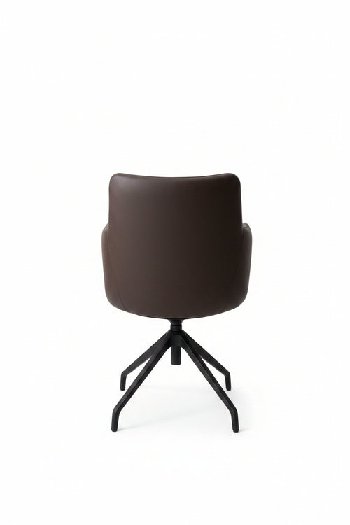 Black chair on a concrete floor with a gray wall in the background