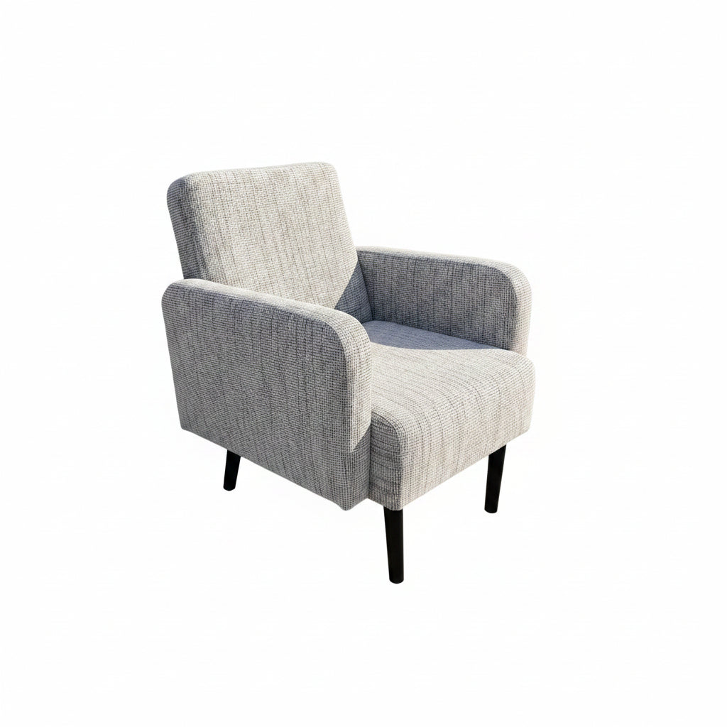 Gray upholstered chair on a concrete floor with a textured wall in the background