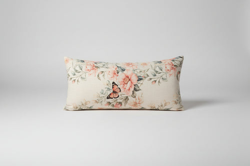 Floral-patterned pillow on a textured sofa with a remote control on the armrest.