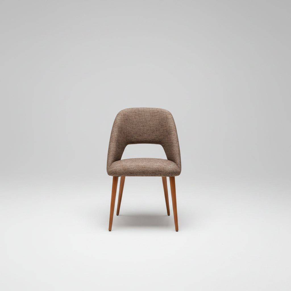 Brown cushioned stool with wooden legs on a concrete surface