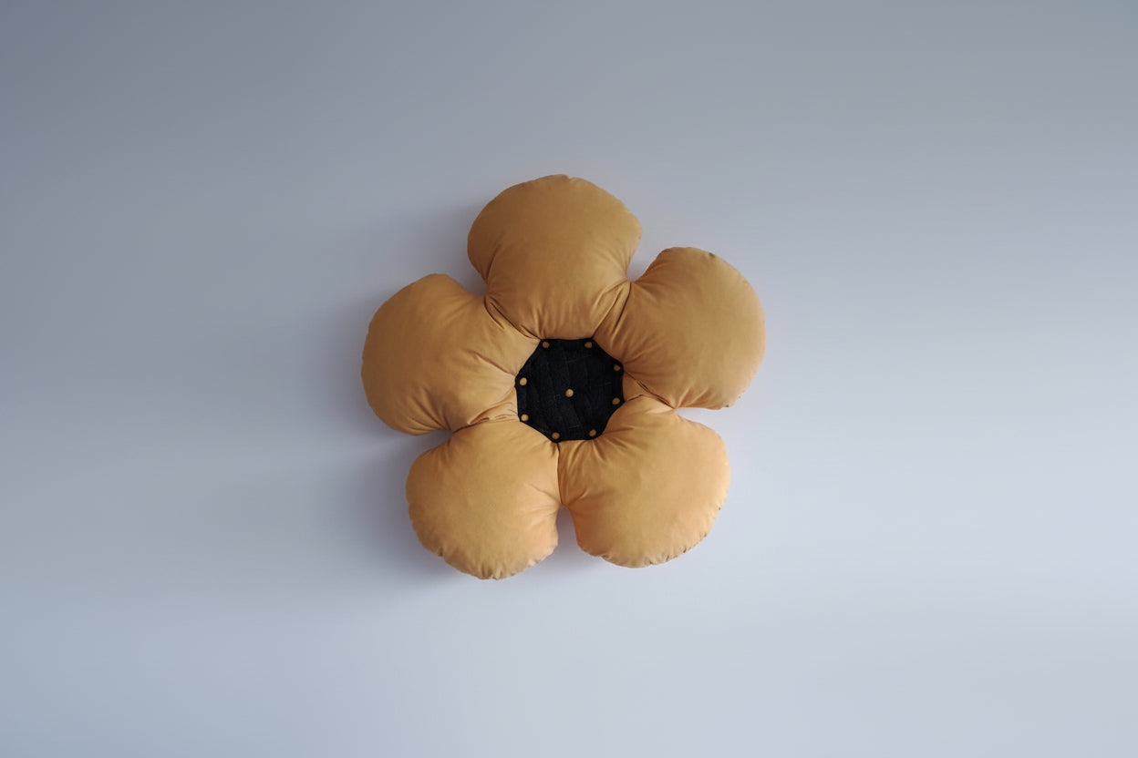 Flower-shaped cushion on a chair against a light blue wall